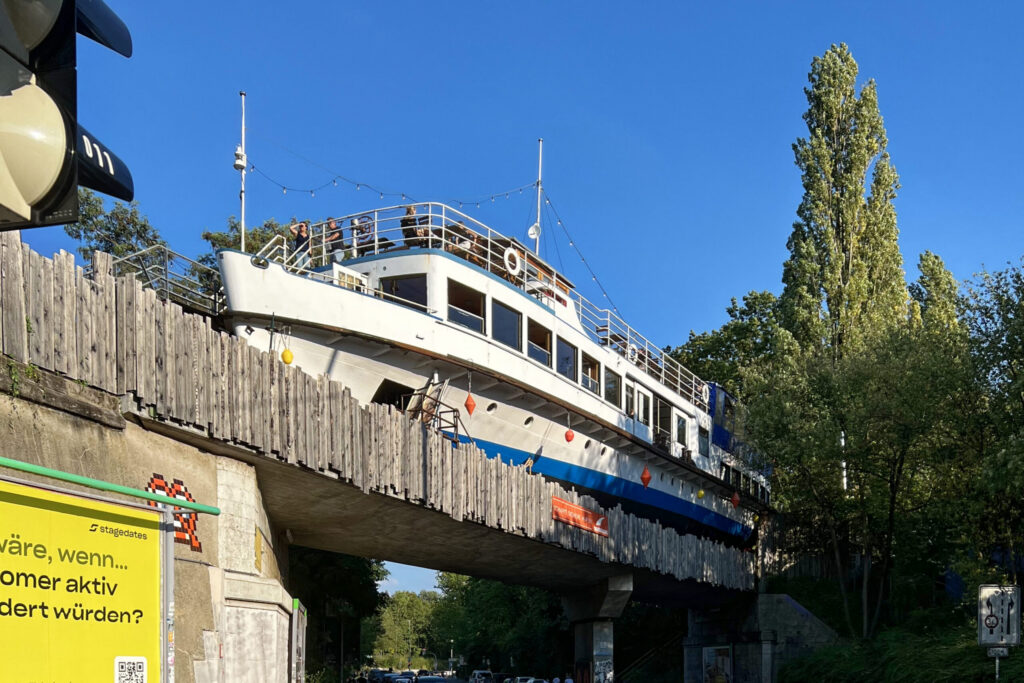 Ein Schiff steht auf einer Brücke über eine Straße.
