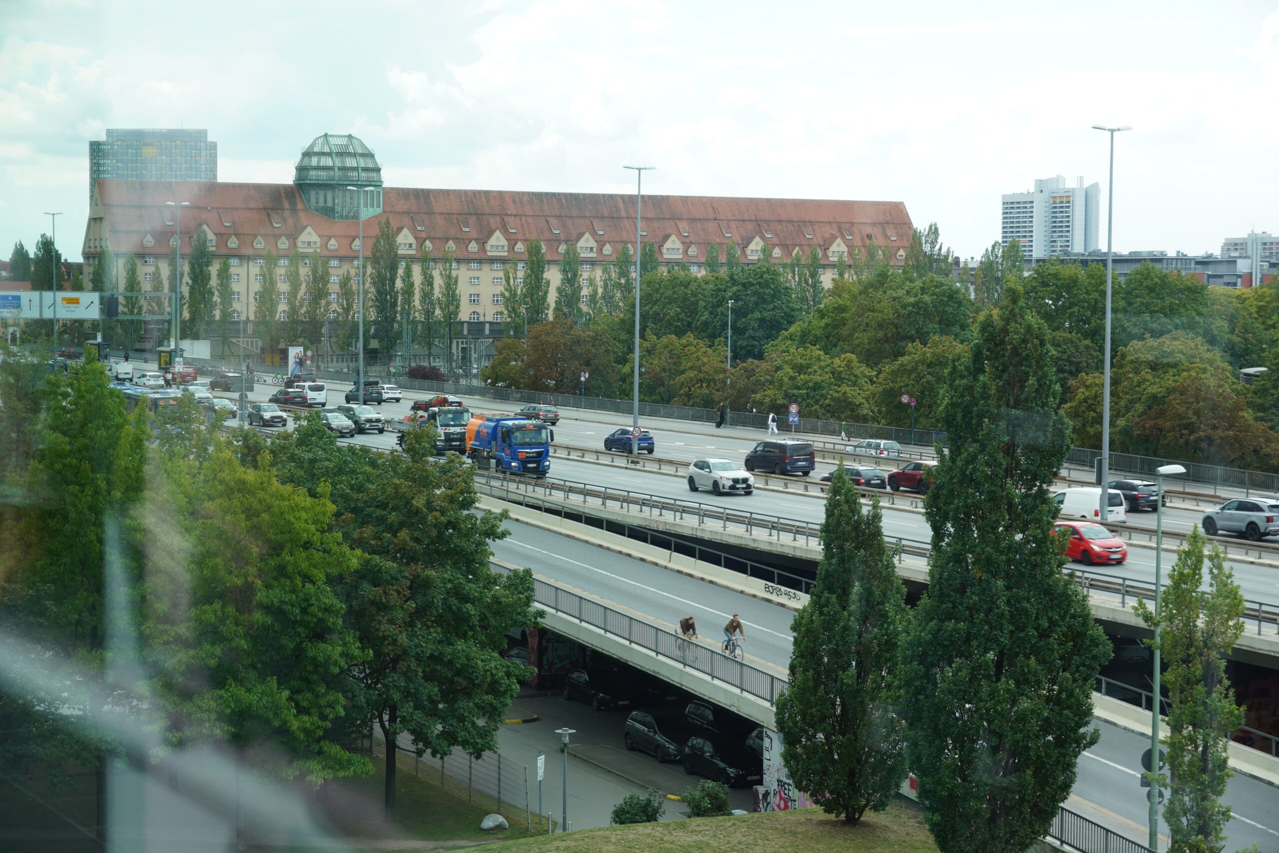 Blick von oben auf eine große Brücke mit Autos, Fahrradfahrern und Fußgängern.
